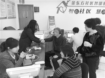 在滨江金东方社区，居民们在保健小屋里进行健康检测。