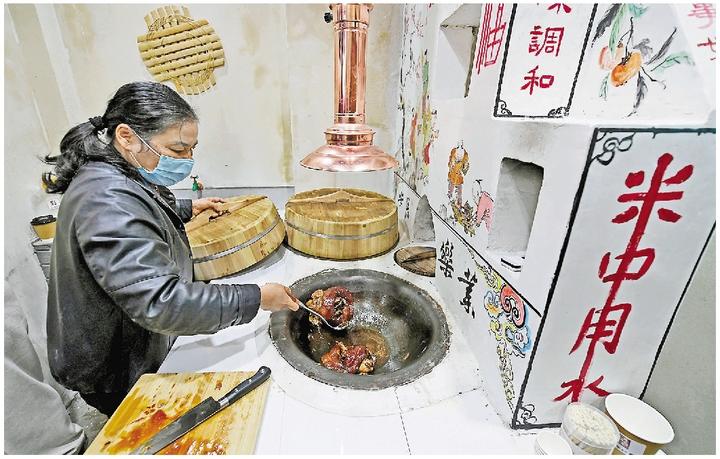 居民在大运河灶画体验馆用土灶烹制红烧蹄髈。记者 李忠 摄