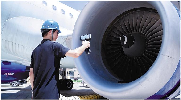 工作人员用无线三维扫描测量仪对飞机引擎进行扫描,构建高精度三维模型。先临三维供图。