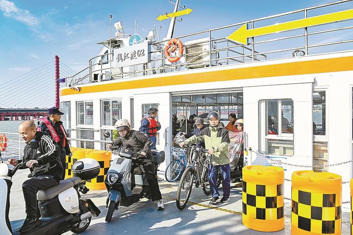 乘客抵达钱塘江南岸后,在工作人员的指引下有序下船。